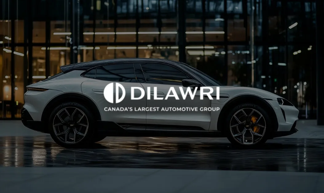 White electric SUV parked in front of modern building at night with Dilawri logo, showcasing Canada’s largest automotive group.